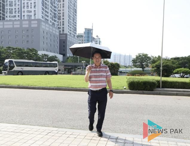 최대호 안양시장이 쿨맵시 데이를 맞아 가벼운 옷차림에 양산을 쓰고 출근하고 있다