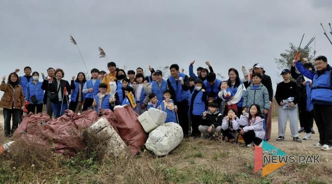 8일 화성시 가족봉사단과 함께하는 자원순환실천 연안정비활동 참가자들이 쓰레기 줍기 활동을 마치고 기념 촬영하고 있다