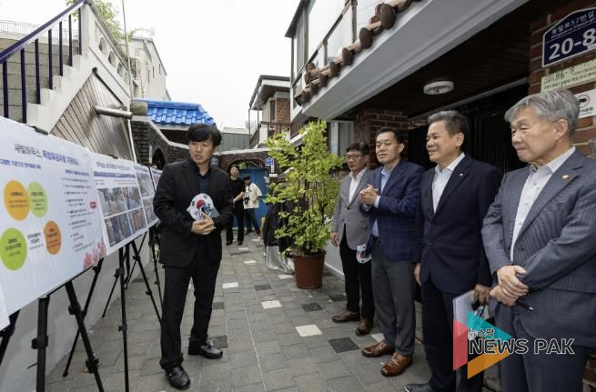 수원시와 한국보훈복지의료공단이 수원지역 독립유공자 후손의 집수리를 지원한 새빛하우스 앞에서 관계자들이 사업 설명을 듣고 있다.