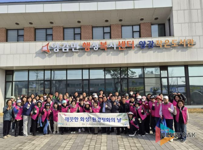 화성시여성단체협의회와 관계자들이 양감면 환경 정화 활동을 기념하고 있다